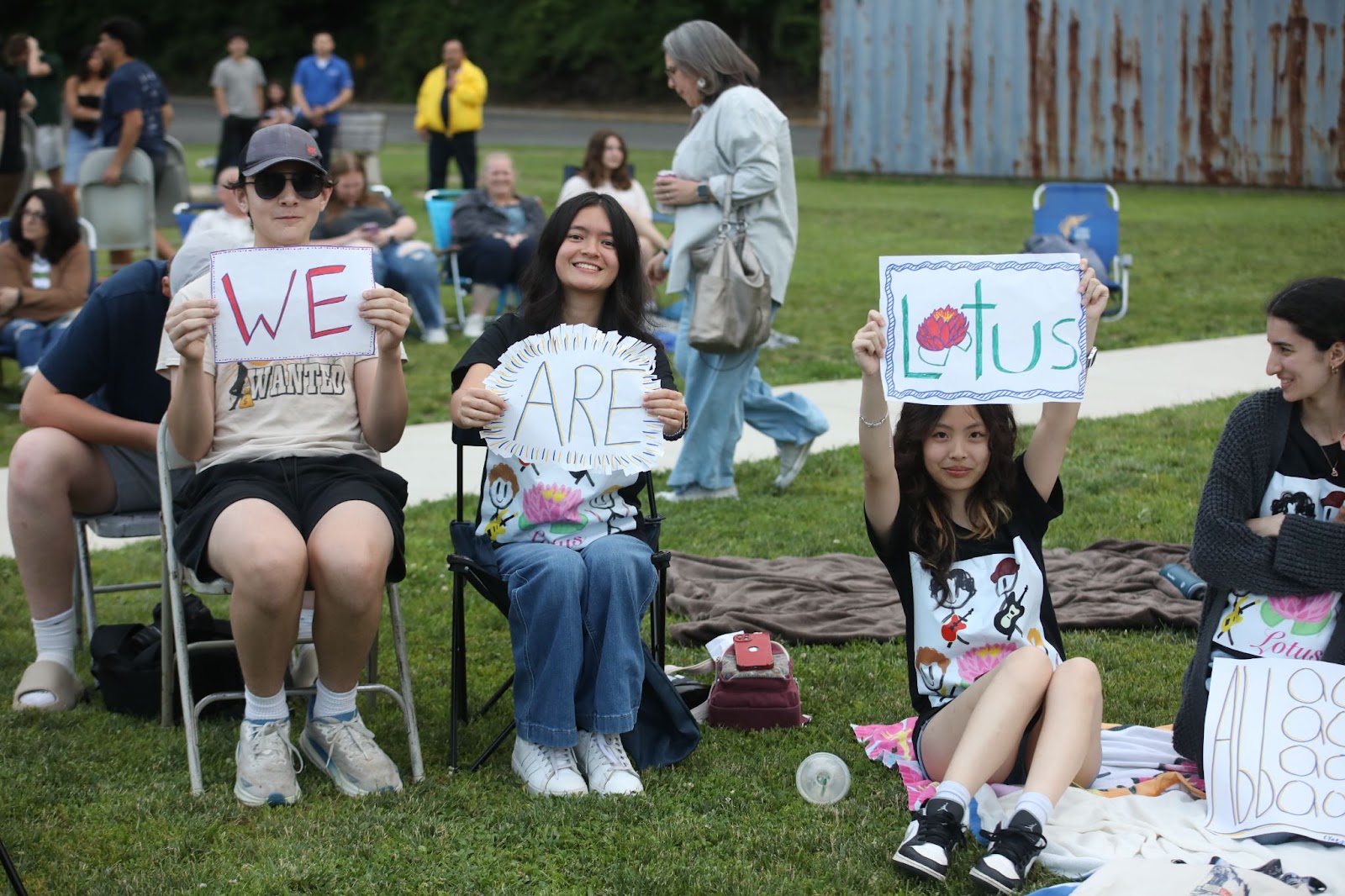fans holding up signs for band