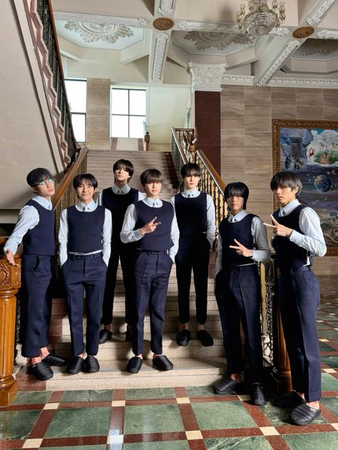 This  contain an image of  SEVENTEEN a group of young men standing next to each other in front of a stair case