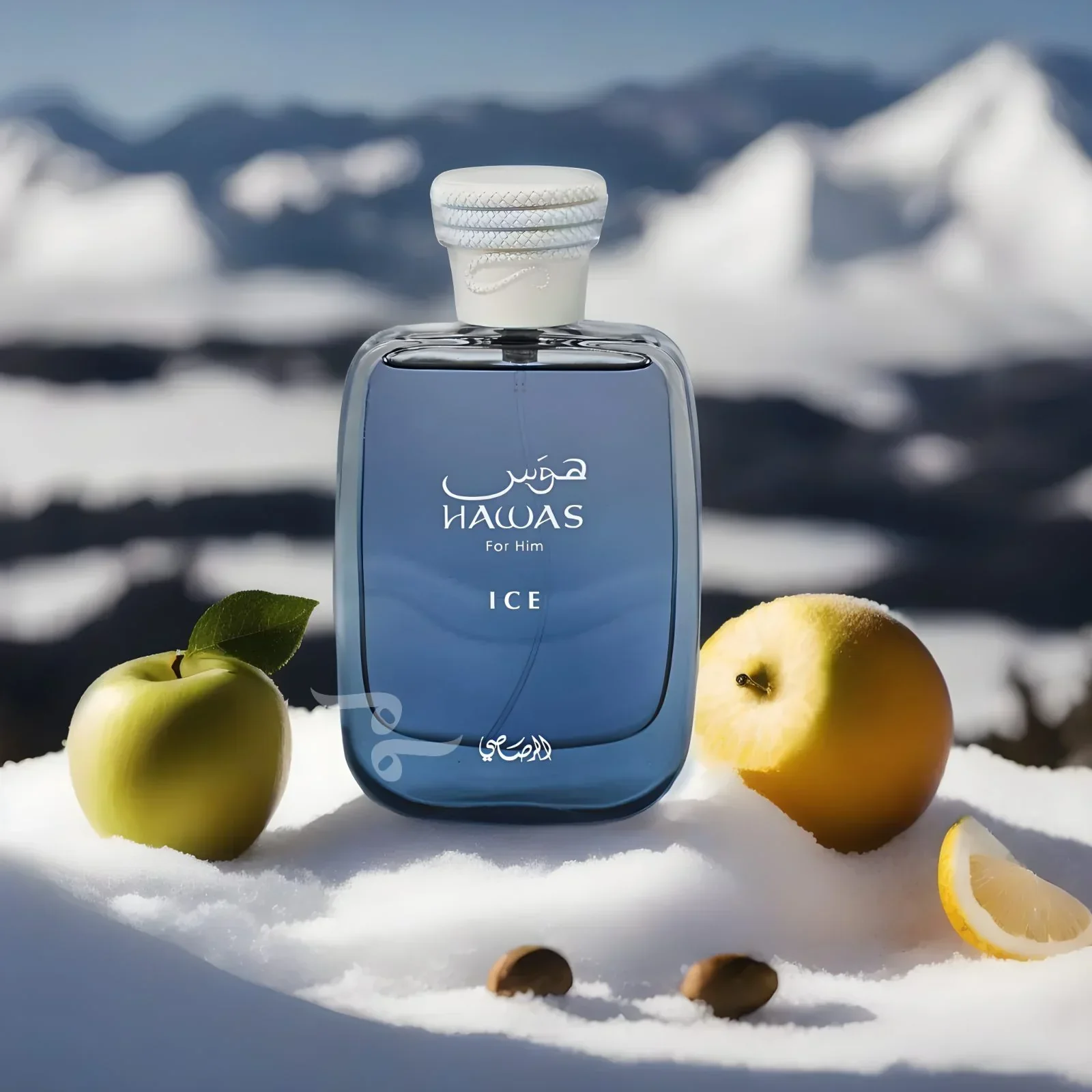 A blue bottle of Hawas Perfume for Men placed on snow with green apples, a lemon slice, and coffee beans in the foreground, with snowy mountains in the background.