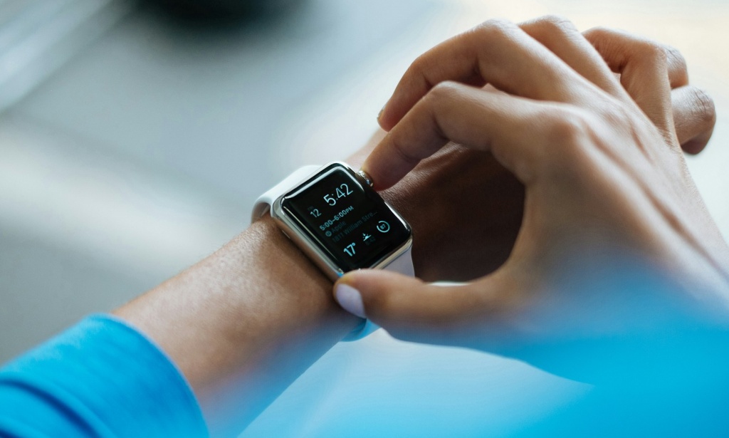 Person wearing blue shirt interacting with an Apple watch on their wrist