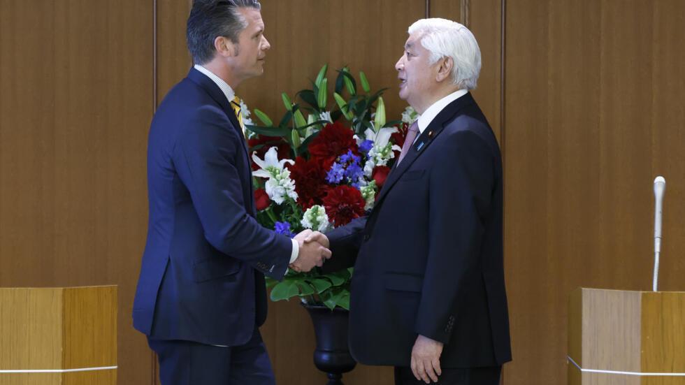 日本防卫大臣中谷元（右）和美国国防部长皮特-黑格塞斯在东京国防部举行的联合新闻发布会上握手。2025 年 3 月 30 日