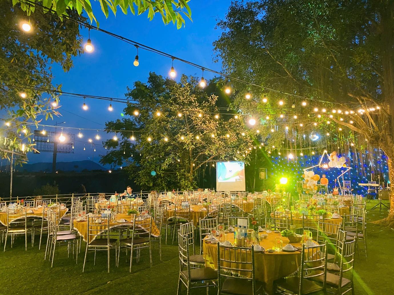 A group of tables and chairs under string lights

Description automatically generated