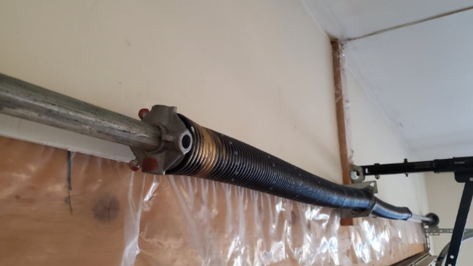 Two torsion springs stretched out of shape on a residential garage.