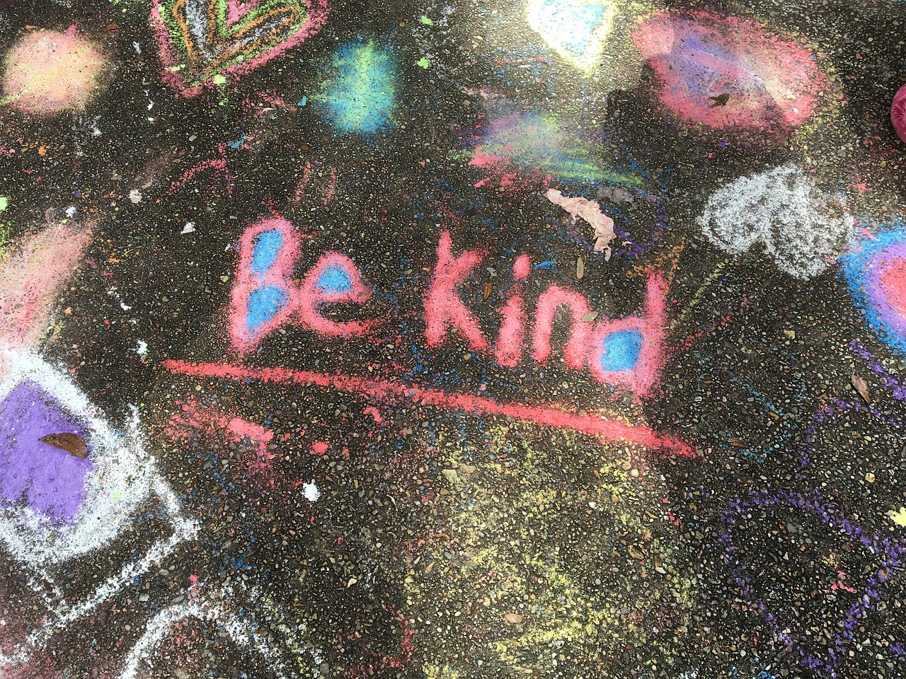 A chalk drawing for being kind. Colorful chalk art in the background. 