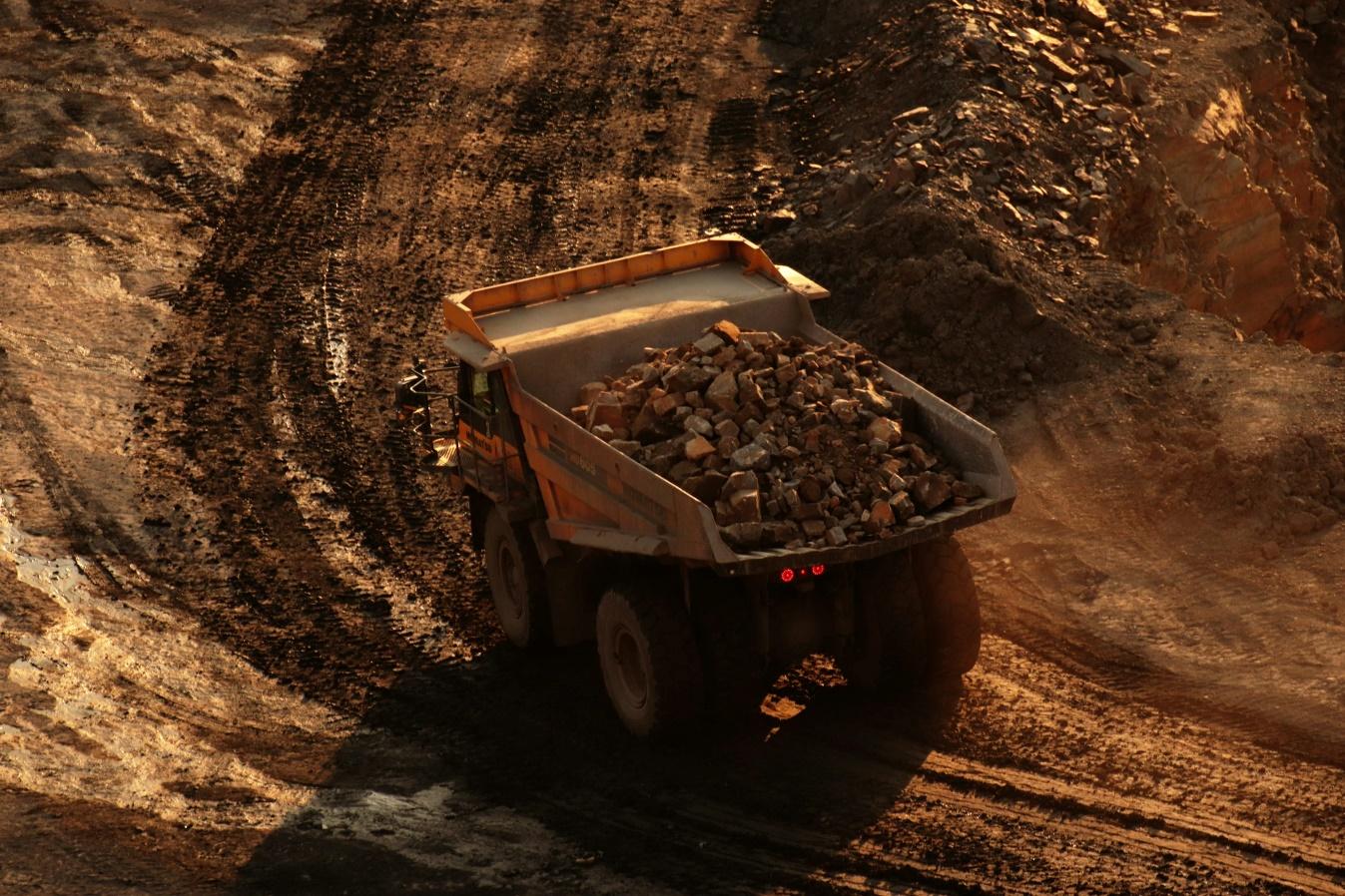 a dump truck driving down a dirt road