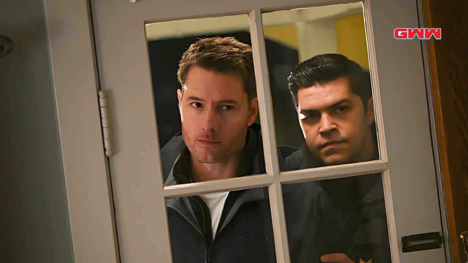 JJustin Hartley and Jason Diaz peering through a window, "Tracker" show