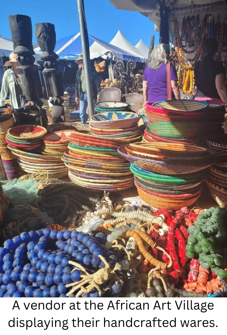 A vendor at the African Art Village displaying their wares.