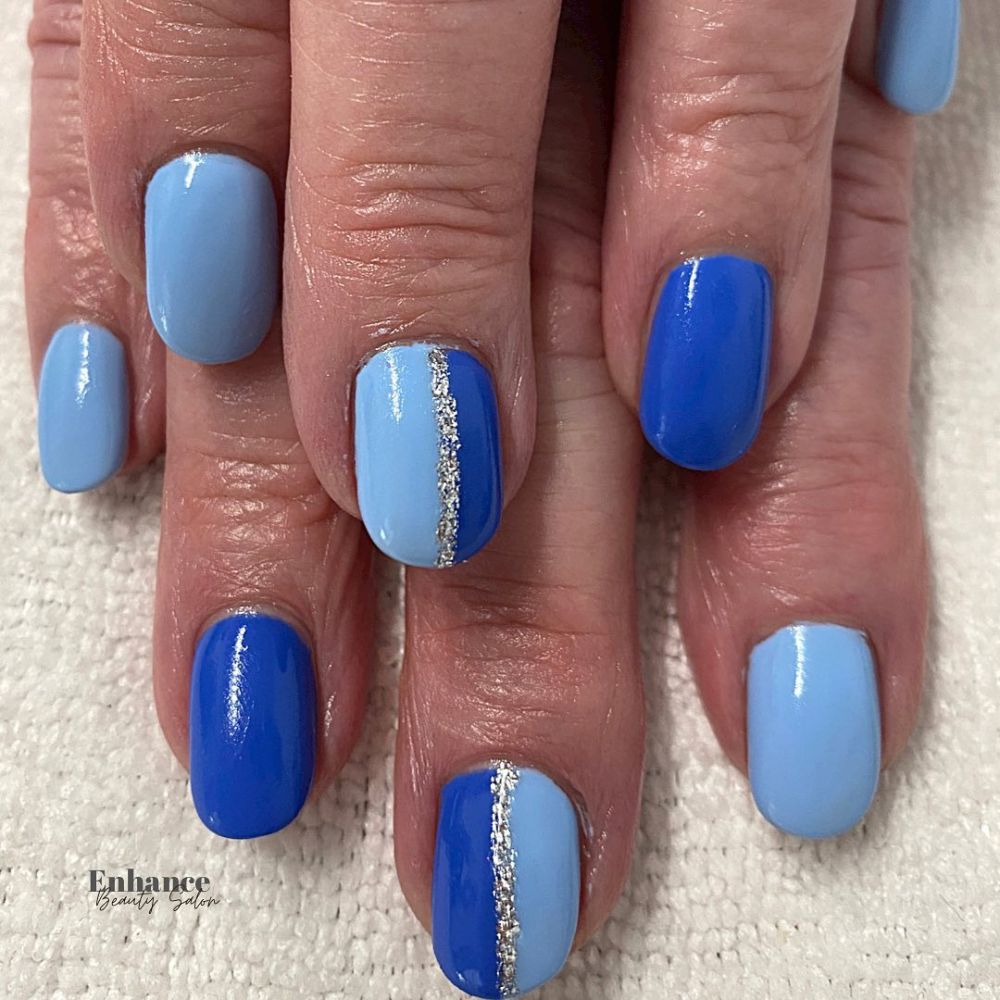 Close up of hands with blue winter nails having Two shades of blue nails