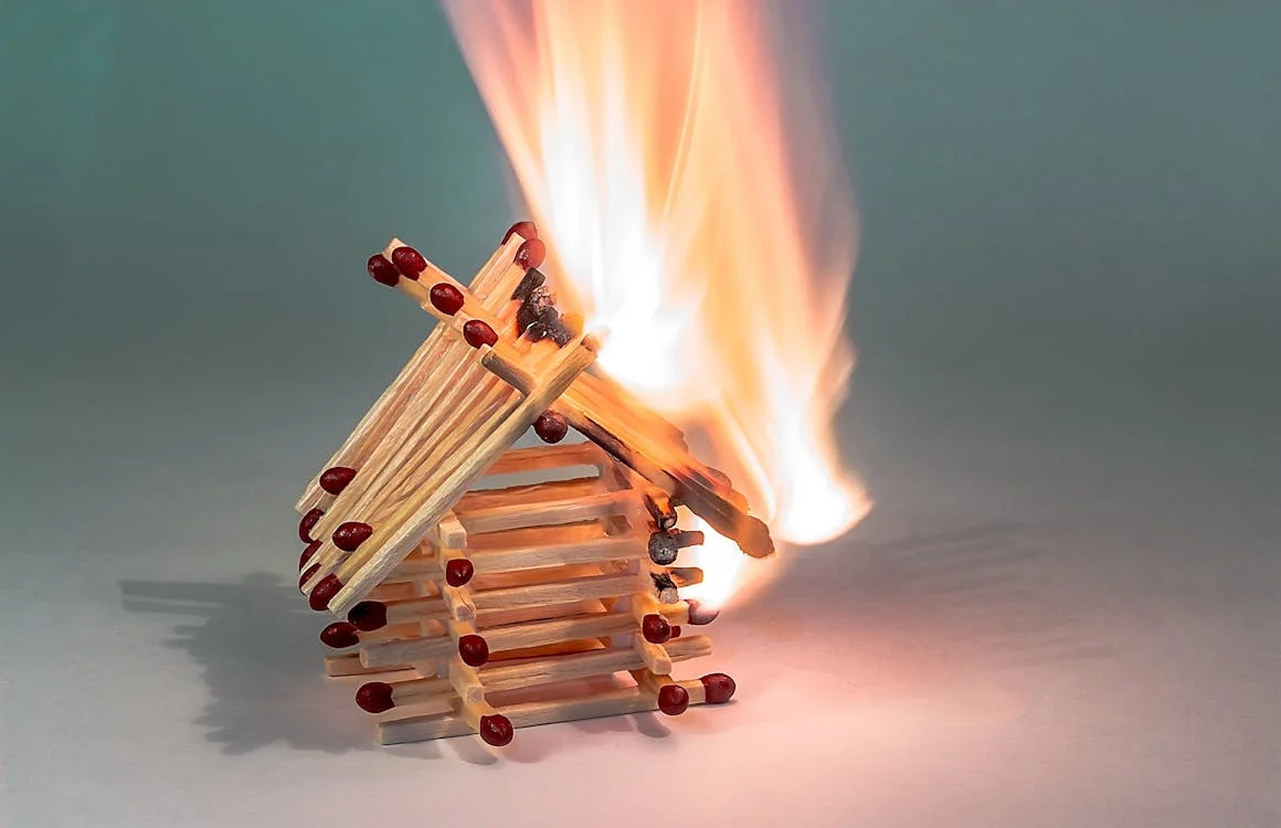 Burning matchstick house symbolizing how operational risk management tools prevent small threats from escalating.