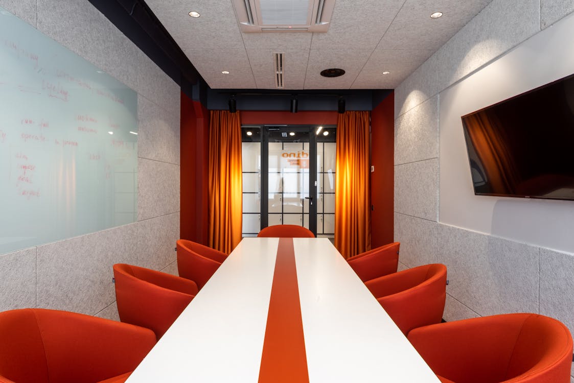 Free Elegant and colorful conference room with orange chairs and modern decor. Stock Photo