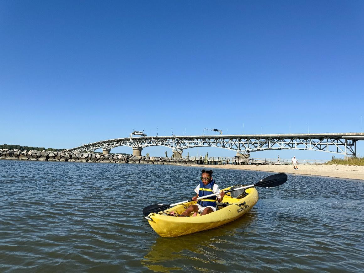 A person in a yellow kayak on the water

Description automatically generated