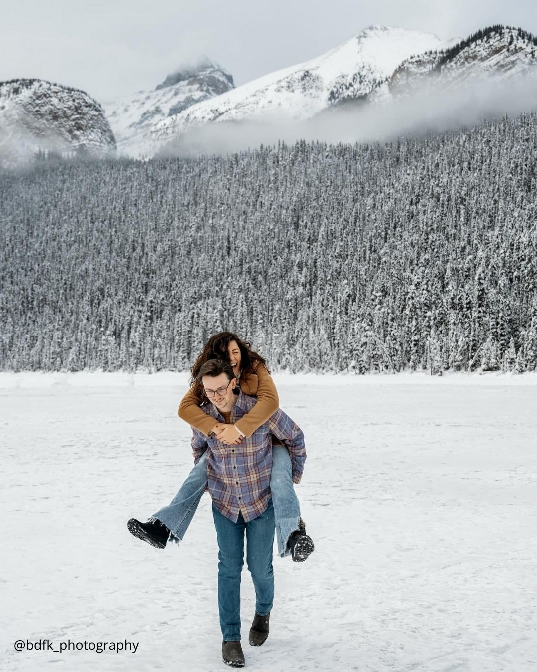 winter engagement photos girl is riding on boys back winter photoshoot