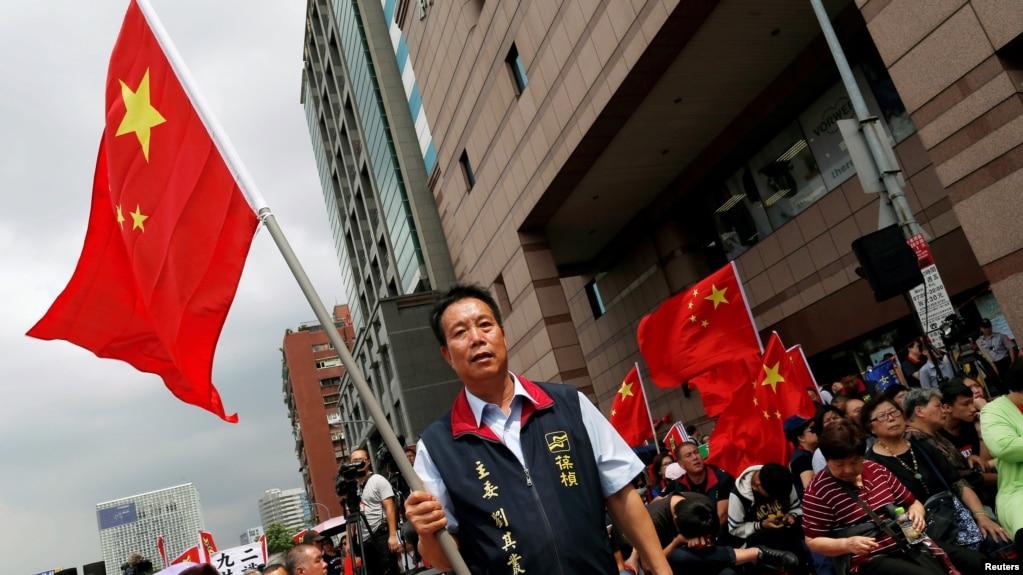 资料照:台湾中华统一促进党在台北街头挥舞五星红旗,呼吁加强两岸关系。(2016年5月18日)
