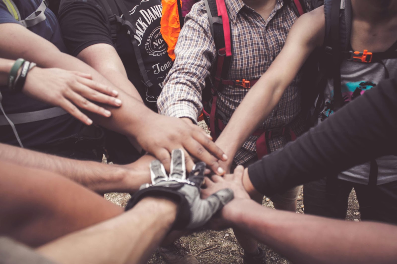 A group of people toucking hands together in unison