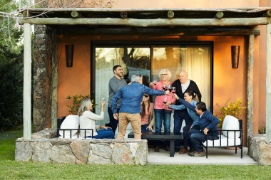 how a home remodeling project can positively impact your family members enjoying dinner on patio with wine toast custom built michigan