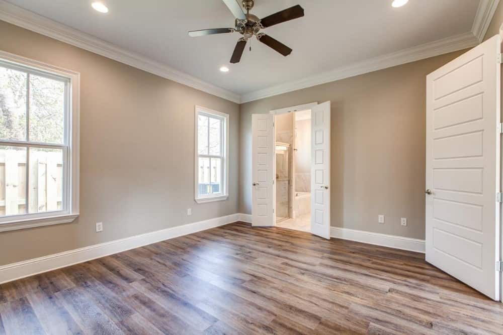 Primary bedroom with gray walls and a regular white ceiling mounted with recessed lights and a ceiling fan.