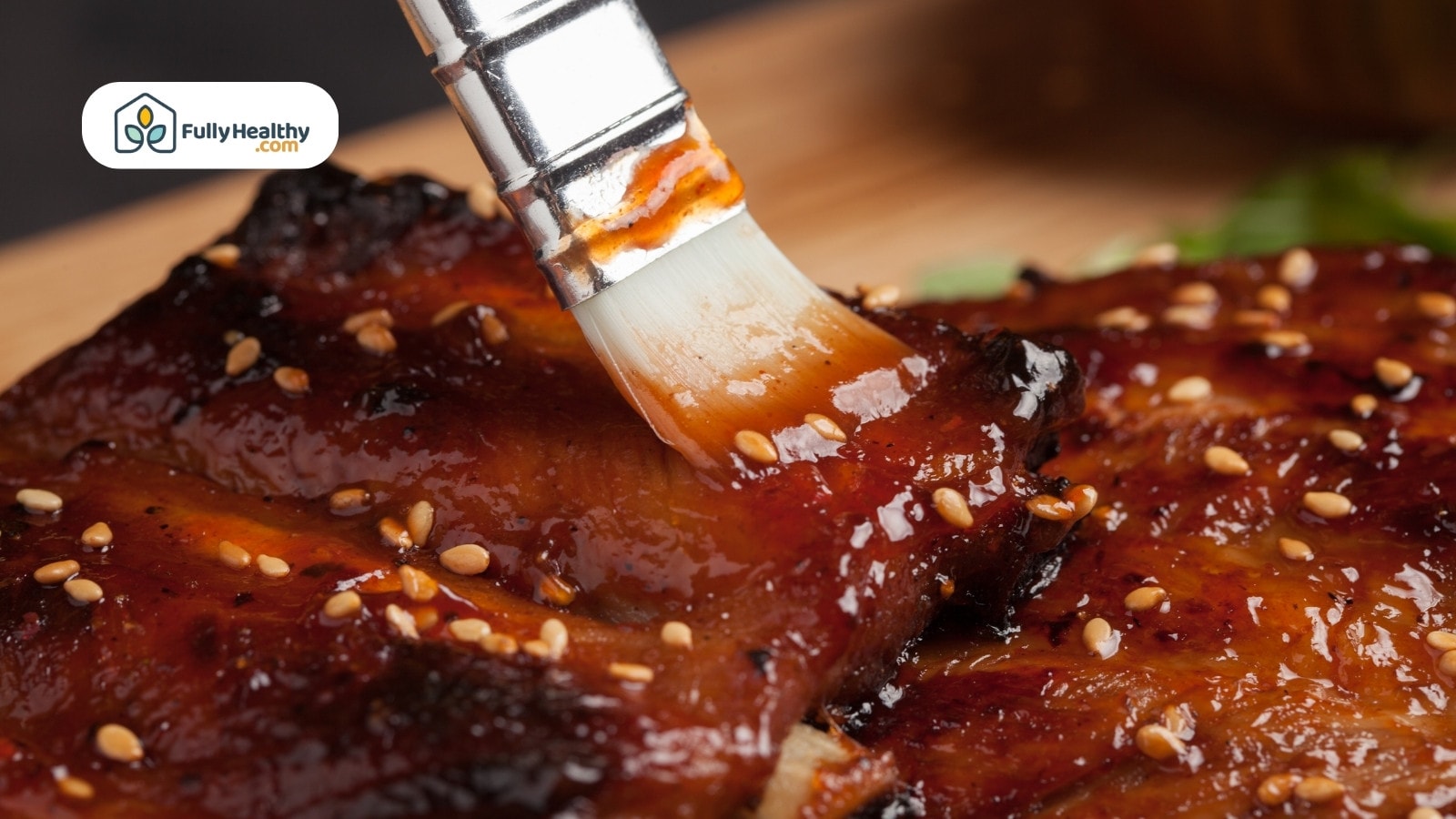 Close-up of sauce being brushed on barbecue ribs
