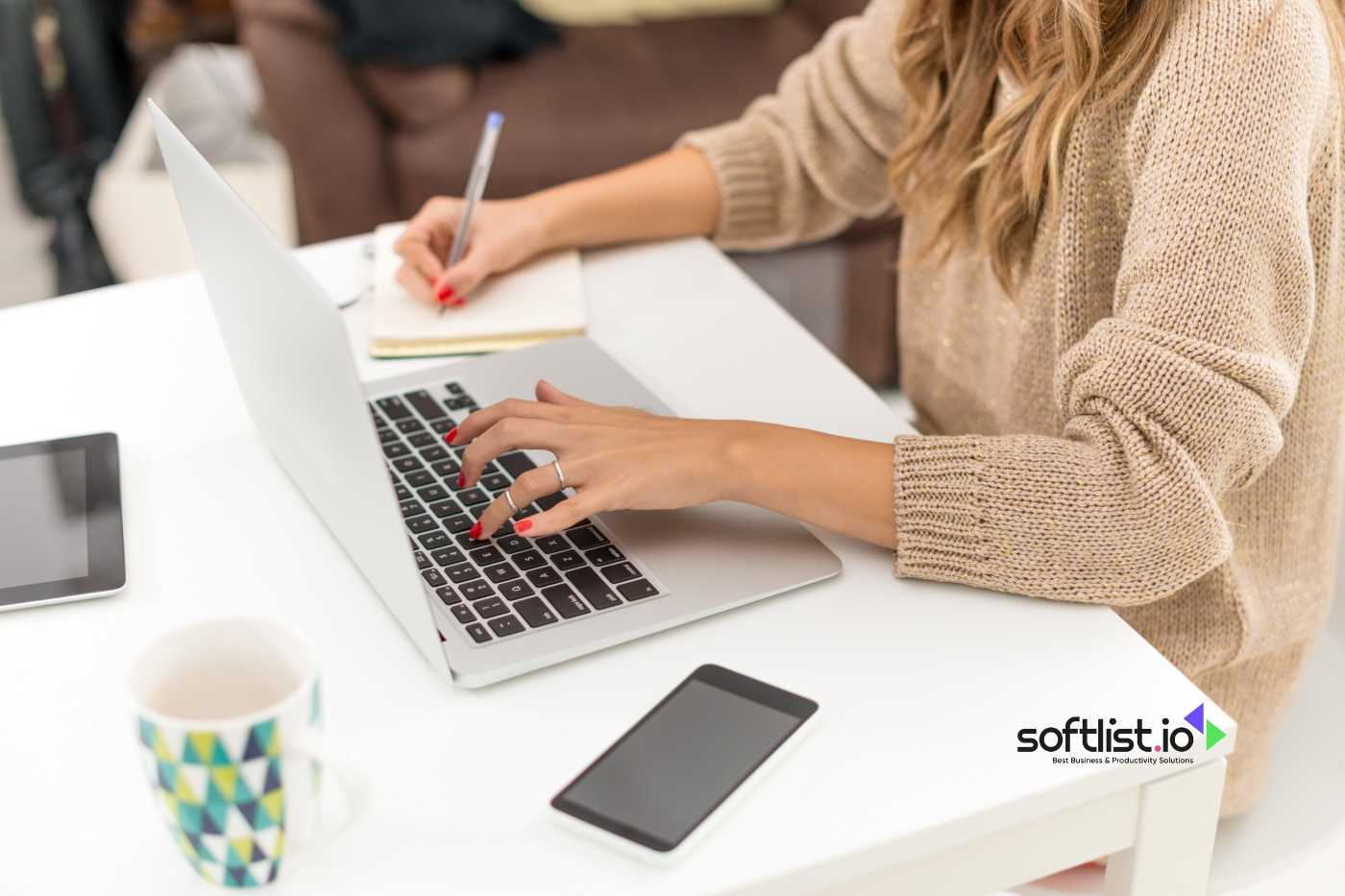 a woman writing and typing on her laptop