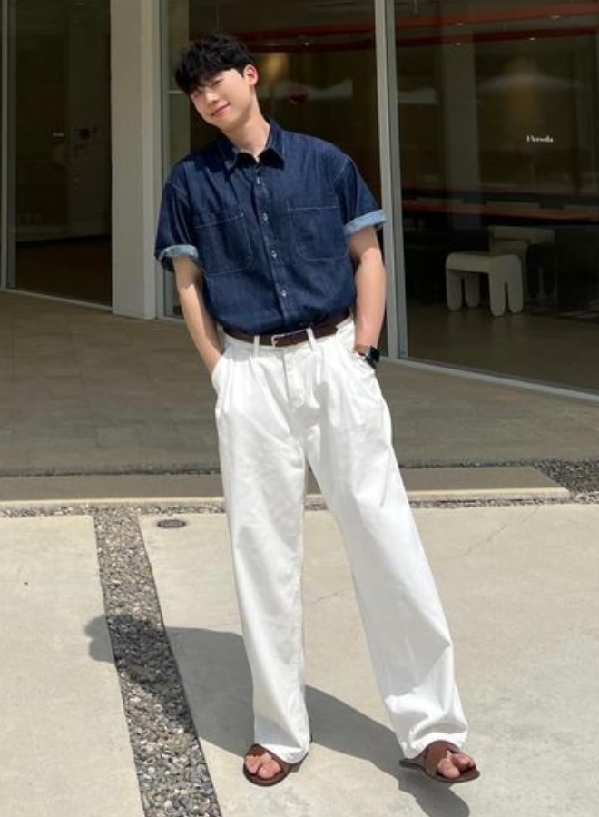 Pria tampil ala Korean Style dengan kemeja denim dan celana putih.
