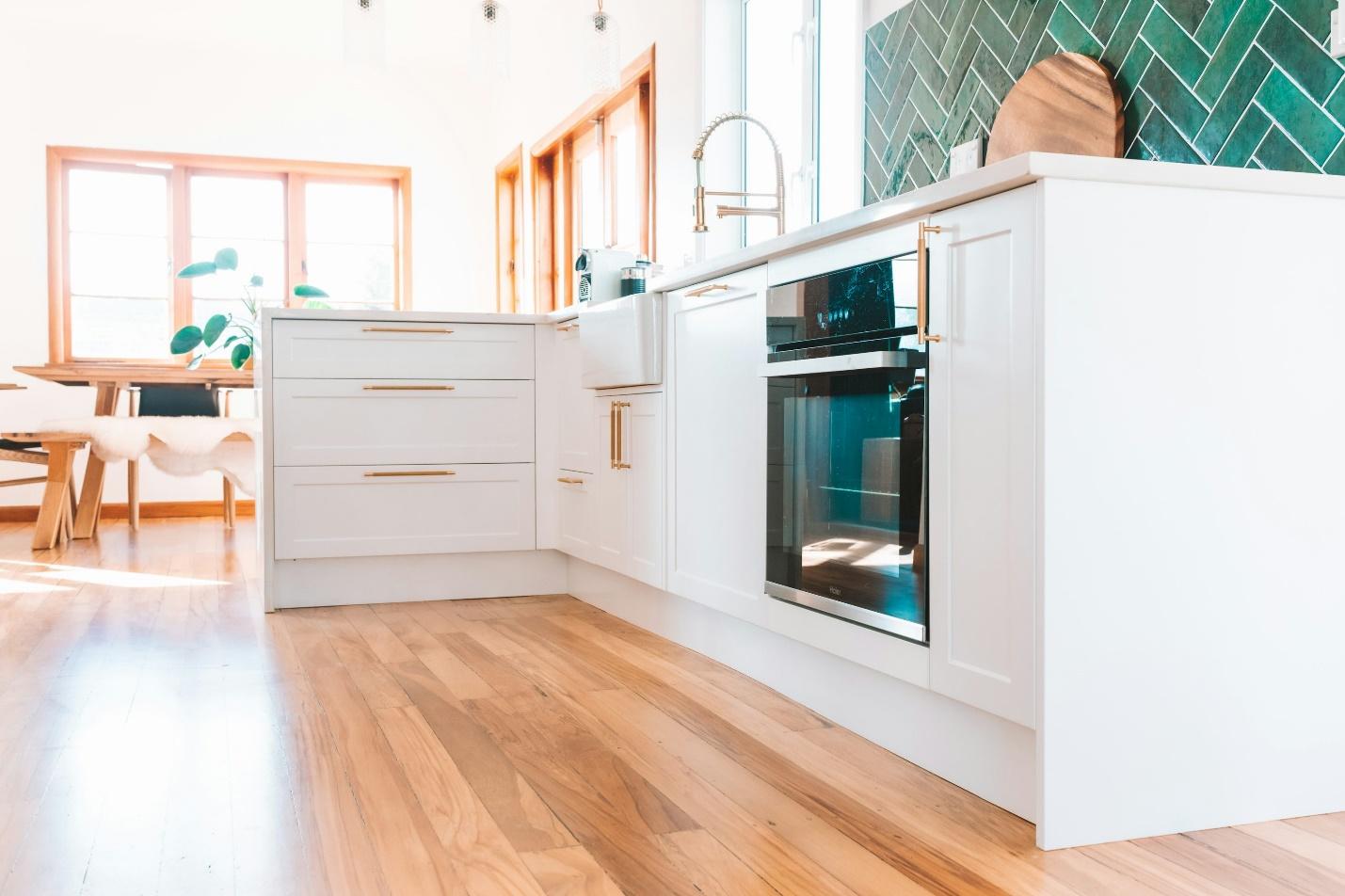 a kitchen with white cabinets and a wood floor