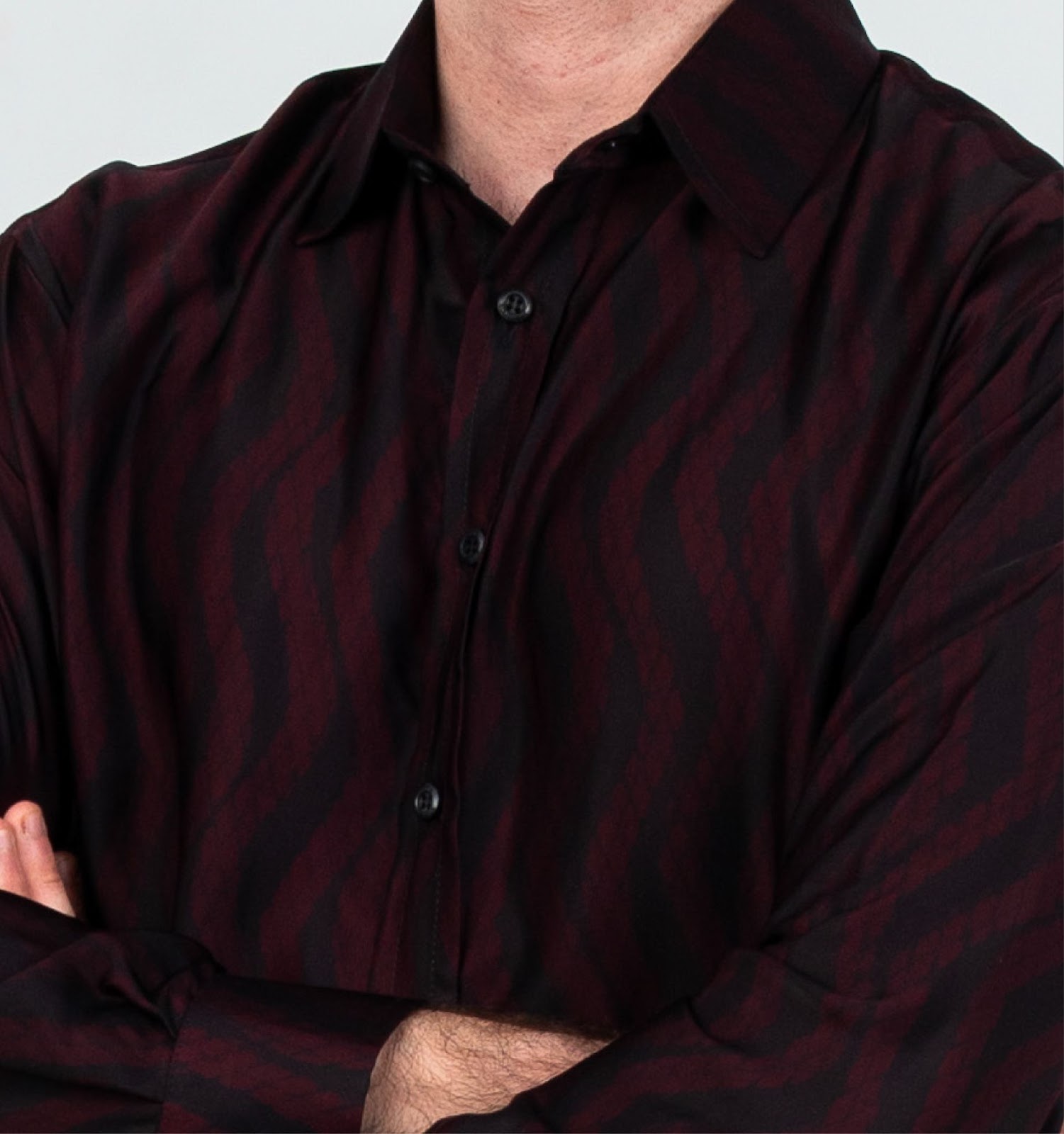 A closeup image showing long sleeved men's batik shirt in garnet snakeskin from batik boutique, standing in a office