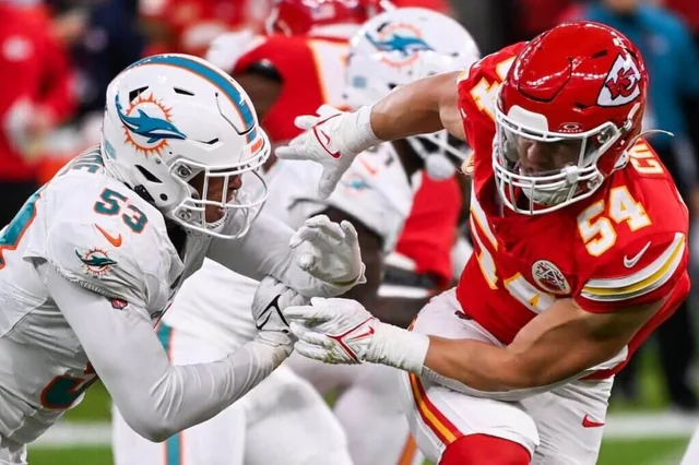 The Chiefs compete against the Dolphins in an intense football match on the field.