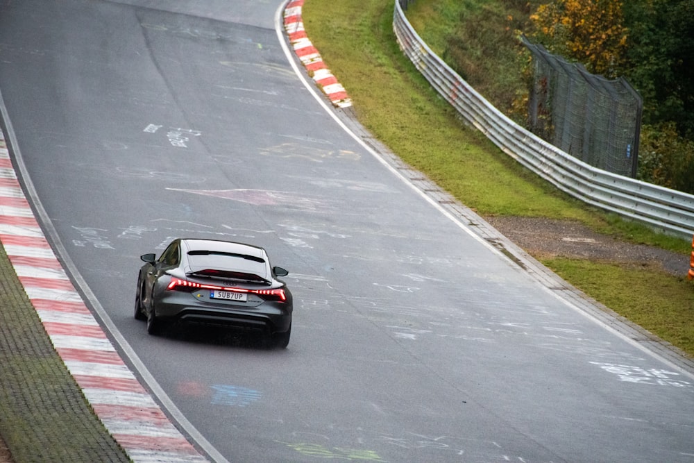 Audi electric e-tron gt. a black sports car driving down a race track