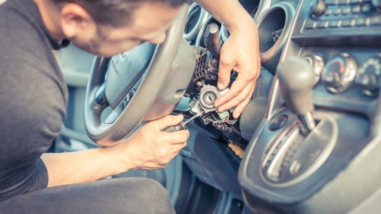 A locksmith fixing a broken ignition switch in a car