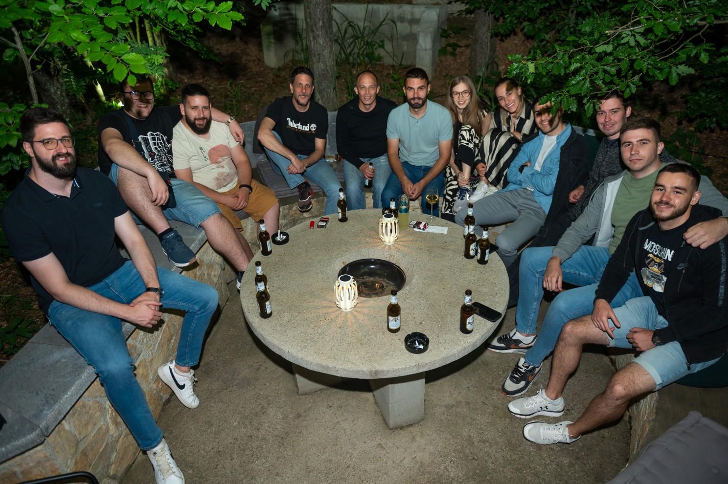 A group of people sitting around a round table

Description automatically generated