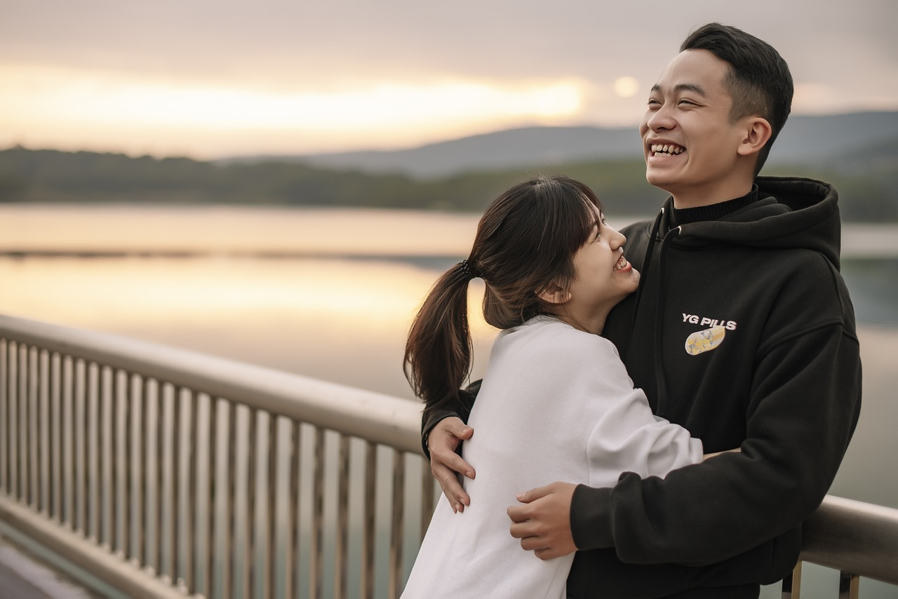 A happy couple by a river during a sunset