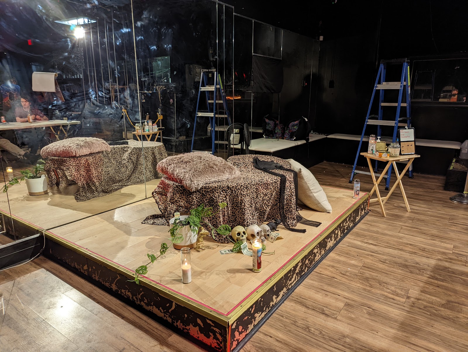 The stage at Wicked Witch with a setup for Drink & Draw figure drawing, featuring a round platform covered in leopard print sheets with a mirrored background.