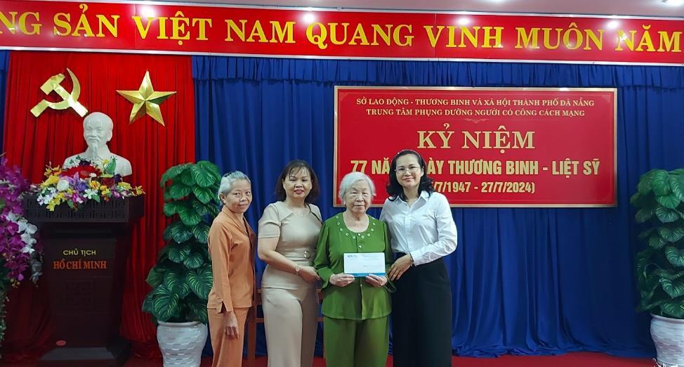 A group of women standing in front of a red and blue bannerDescription automatically generated