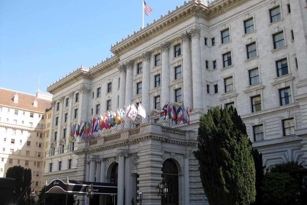 White color building is there and so many flags on the building and on the top of building USA's flag there