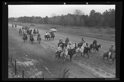 A group of people riding horses on a road

AI-generated content may be incorrect.