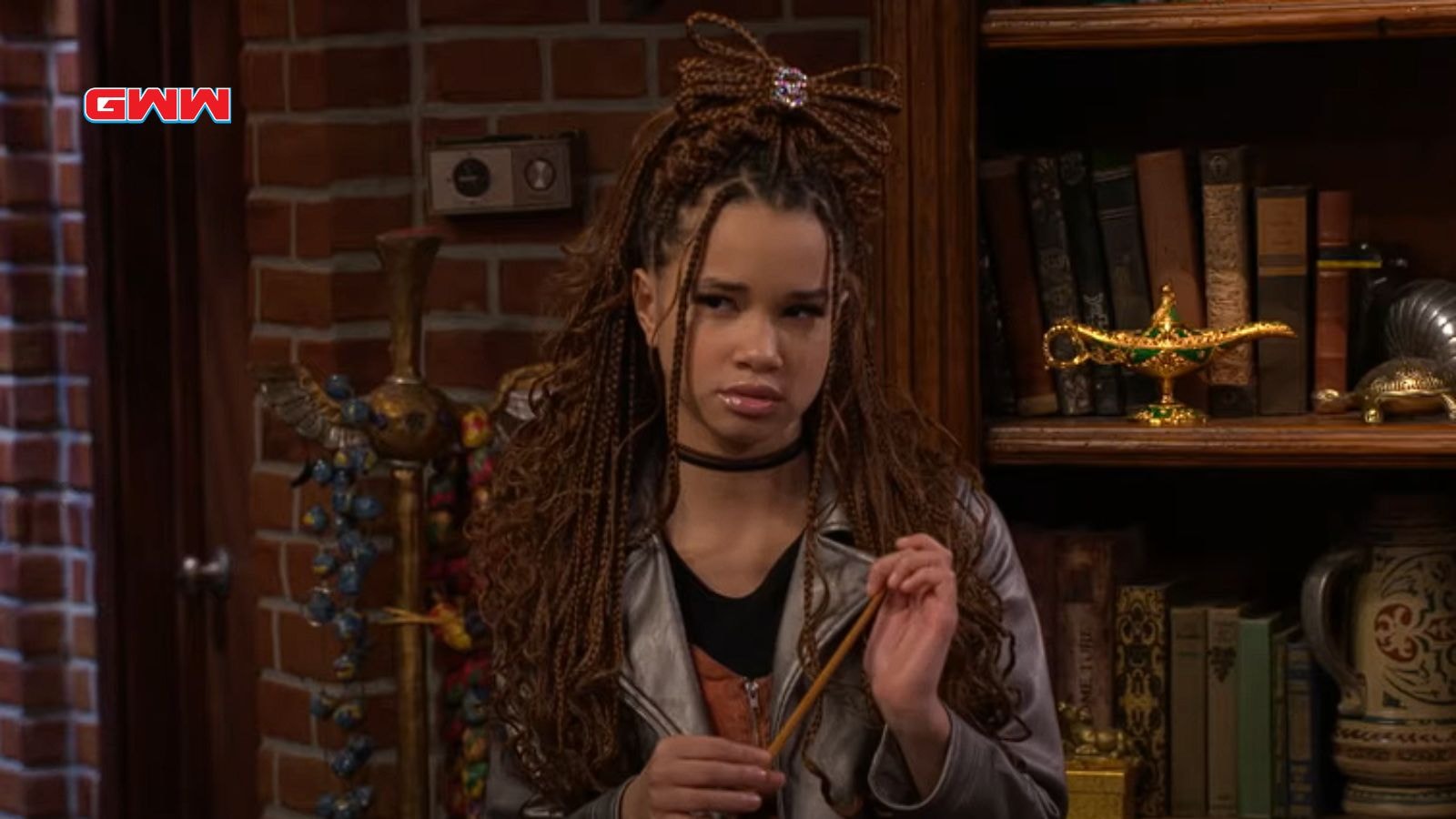 Janice Leann Brown holding a wand in a library scene from Wizards Beyond Waverly Place