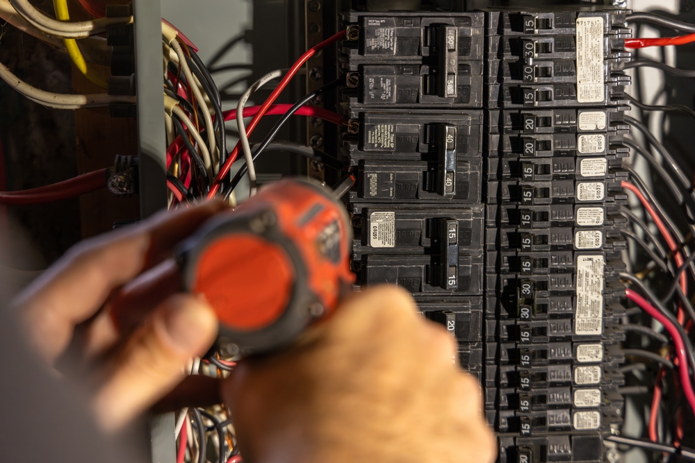 A professional electrician replaces a home circuit breaker.