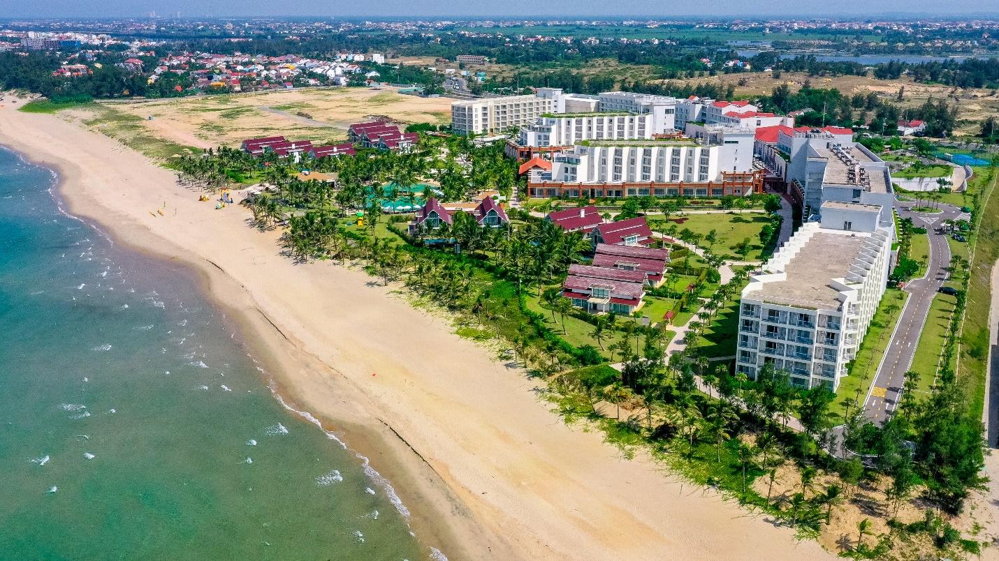 A beach with buildings and trees

Description automatically generated