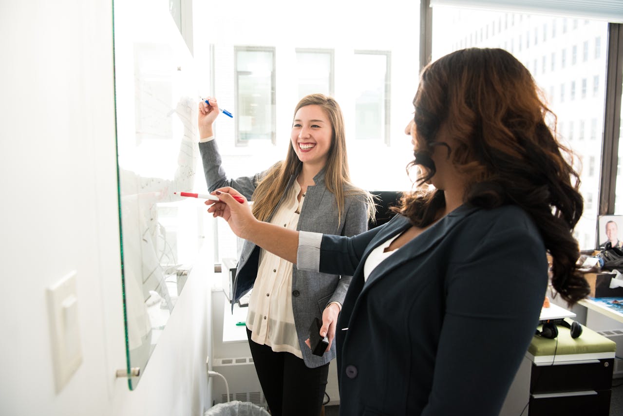 Team members writing their quarterly planning agenda on a white board 