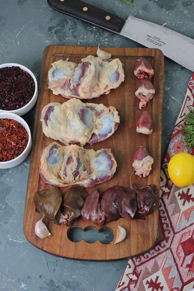 A cutting board with raw meat

Description automatically generated