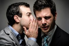 This may contain: two men in suits are touching noses with each other while one man covers his mouth