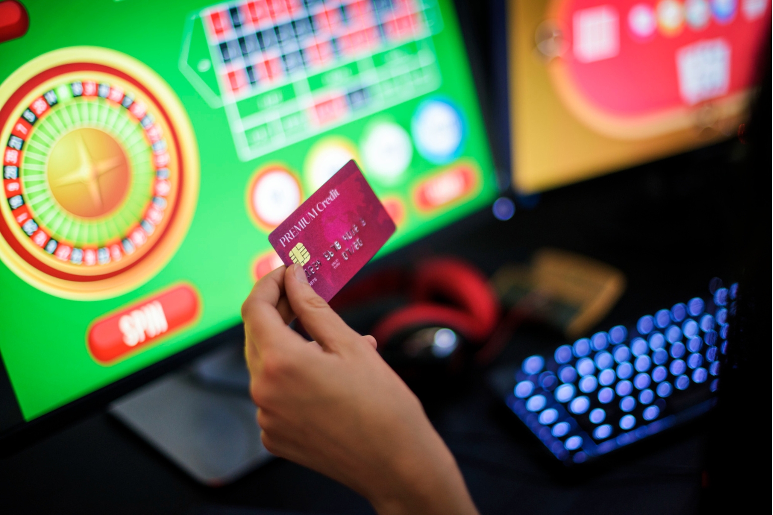 A person excitedly holds a credit card, ready to play a casino game.