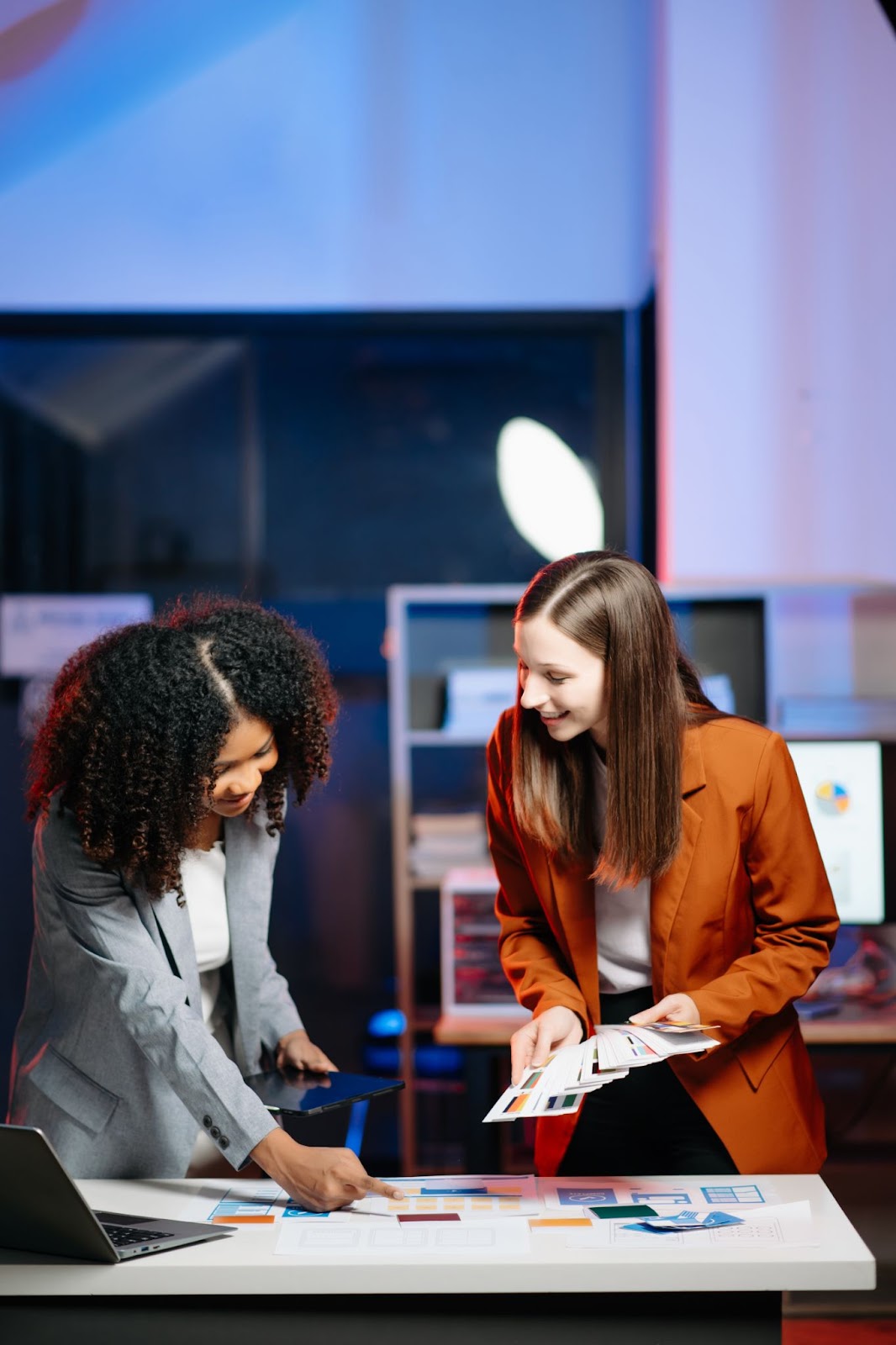 Two corporate women discussing how to design an eye-catching trade show booth together