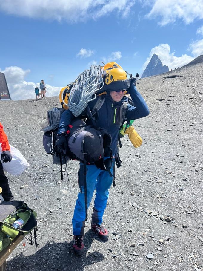A person wearing a helmet and backpack on a mountainAI-generated content may be incorrect.