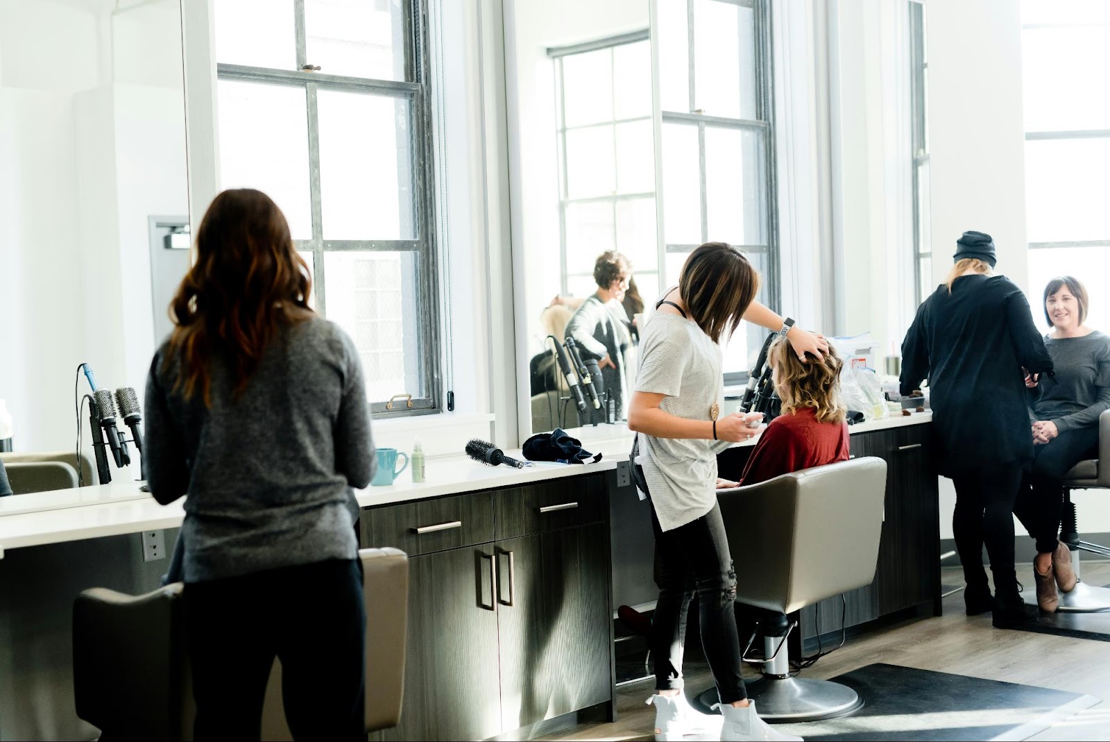 Busy salon with stylists working on clients’ hair and clip-in extension styles