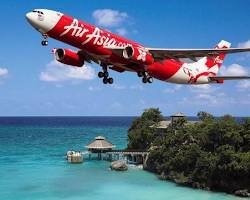 Image of AirAsia plane flying over a tropical island