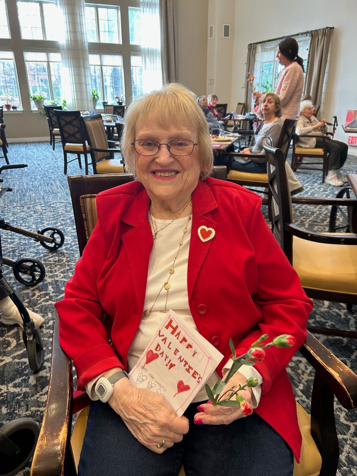 Woman in red jacket holding Valentine's card