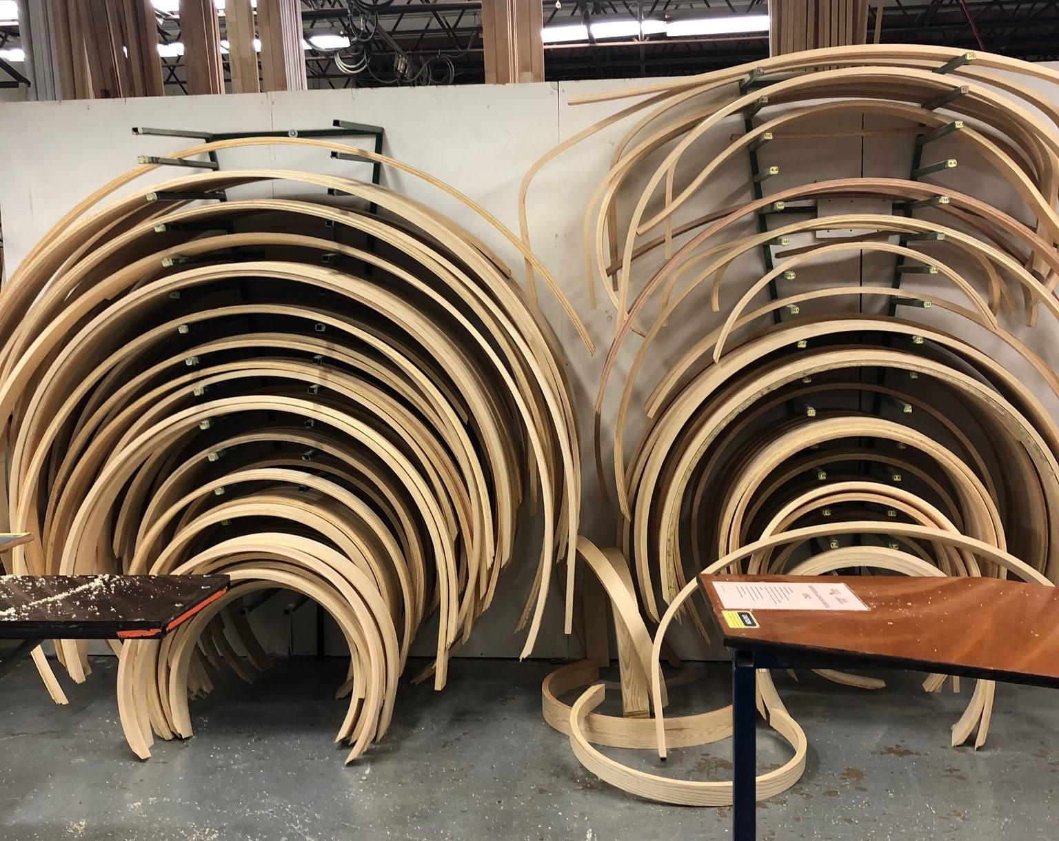 A group of wooden chairs stacked in a warehouse

Description automatically generated