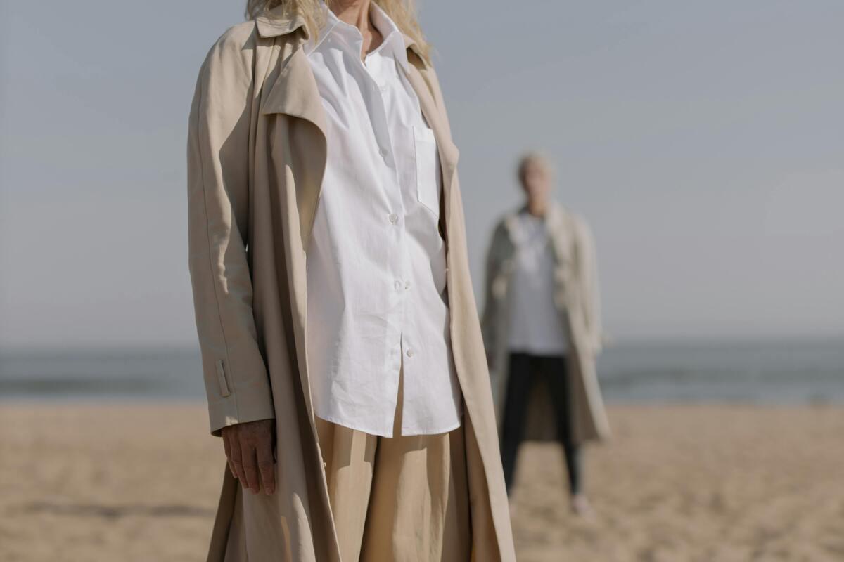 Two people wearing trench coat on the beach
