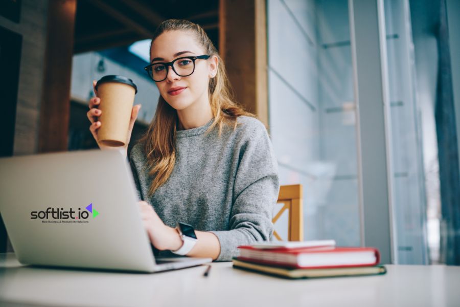 Woman enjoying coffee while working on a laptop at a café.