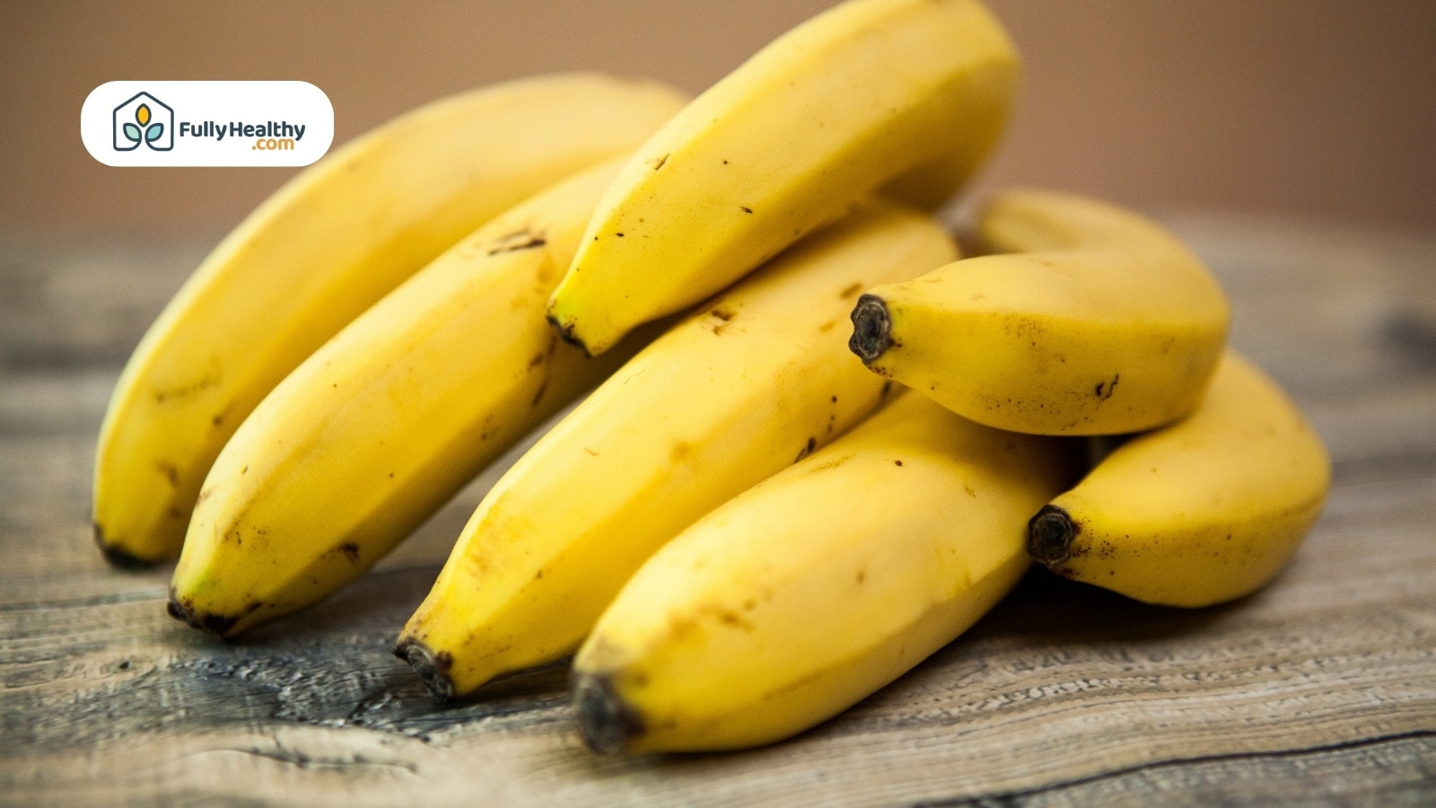 Ripe yellow bananas on rustic wooden surface